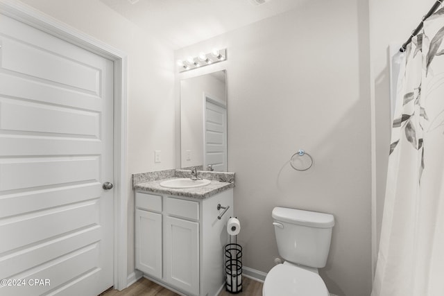 bathroom featuring vanity, hardwood / wood-style flooring, and toilet