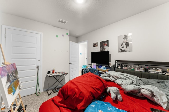 bedroom with carpet and a textured ceiling