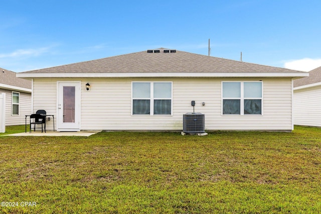 back of property with central air condition unit, a yard, and a patio