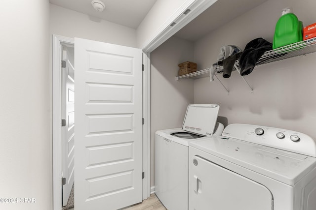 laundry room with separate washer and dryer and light wood-type flooring