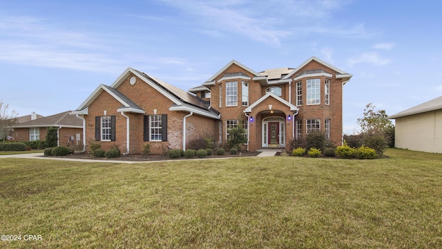 view of front of house featuring a front yard and solar panels