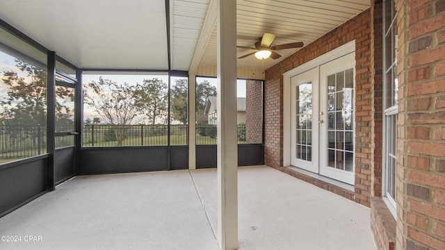 unfurnished sunroom featuring ceiling fan and french doors