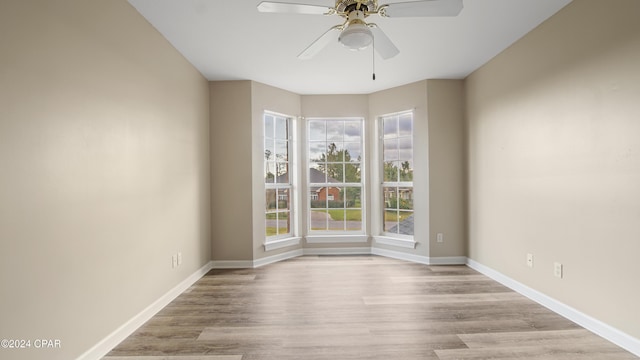 spare room with light wood-type flooring and ceiling fan