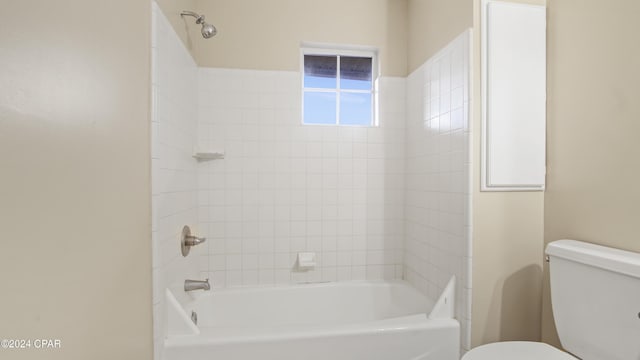 bathroom with toilet and tiled shower / bath combo