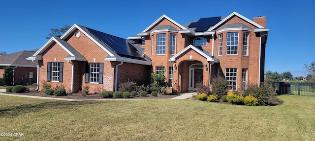 view of front of house featuring a front lawn and solar panels