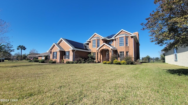 view of front of house with a front lawn and solar panels