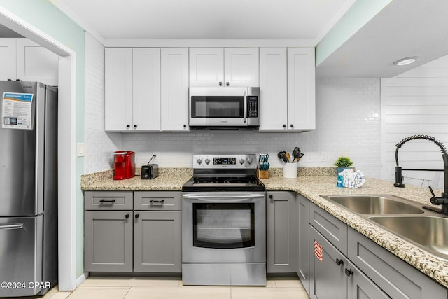 kitchen featuring white cabinetry, sink, stainless steel appliances, gray cabinets, and light tile patterned flooring