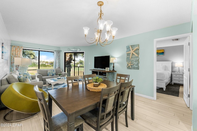 dining space featuring light hardwood / wood-style floors and a chandelier