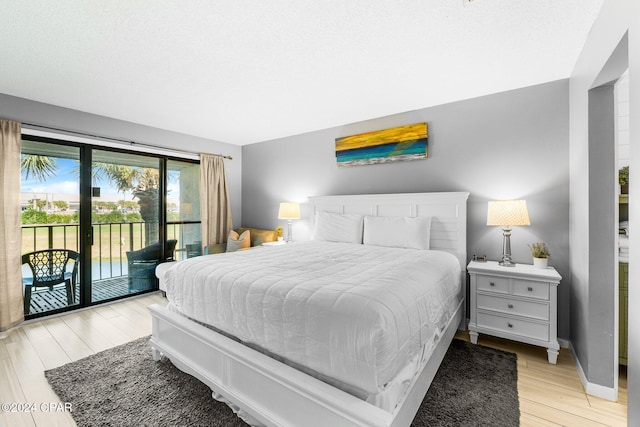 bedroom featuring access to exterior and light hardwood / wood-style flooring