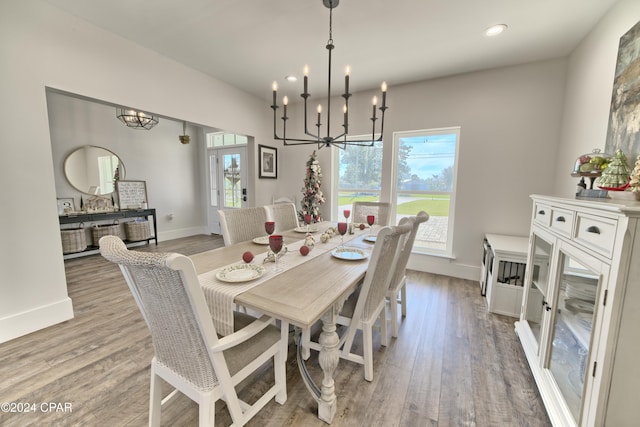 dining space with light hardwood / wood-style floors and an inviting chandelier