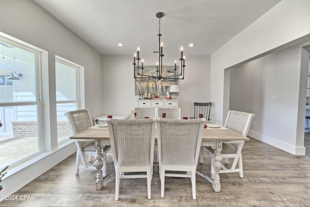 dining space featuring wood-type flooring and a chandelier