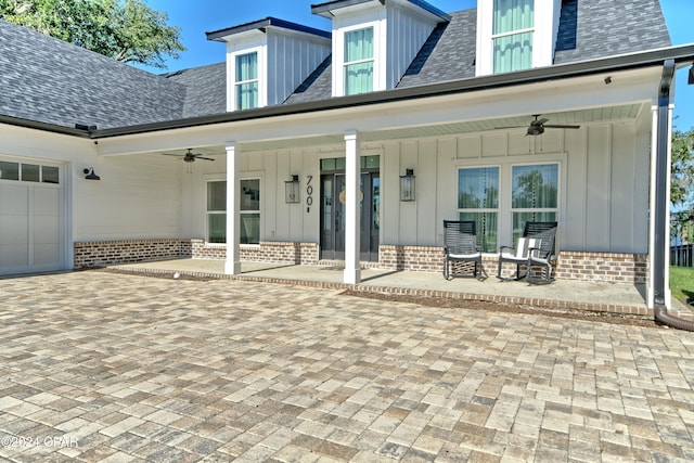 back of property with a porch, a garage, and ceiling fan