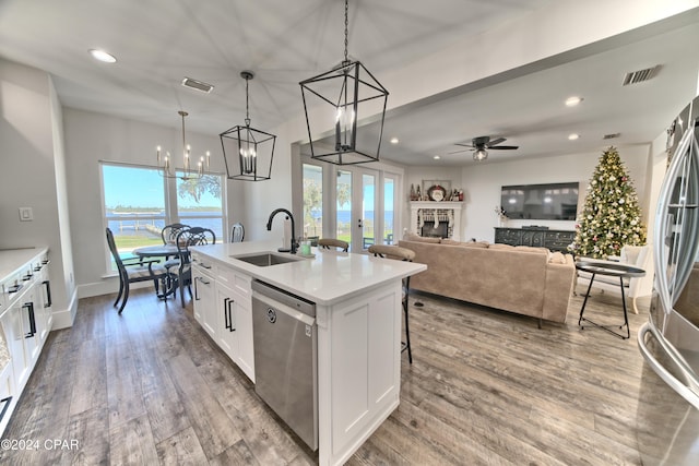 kitchen with pendant lighting, white cabinets, a center island with sink, sink, and stainless steel appliances