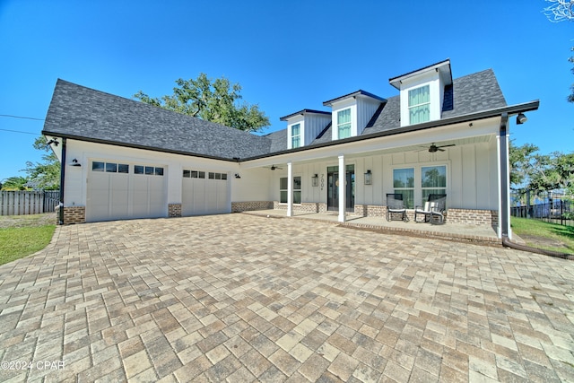 cape cod-style house featuring ceiling fan, covered porch, and a garage