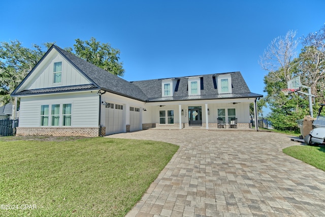 rear view of house featuring a lawn, a porch, and a garage