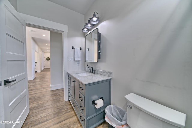 bathroom featuring hardwood / wood-style floors, vanity, and toilet