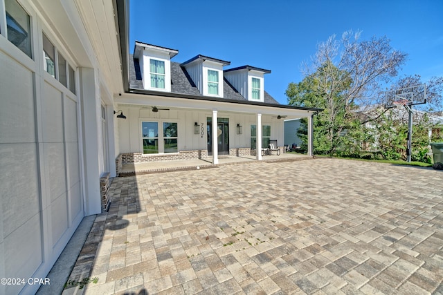 back of house with ceiling fan and a porch