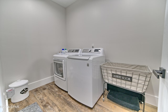 laundry area featuring washing machine and dryer and hardwood / wood-style flooring