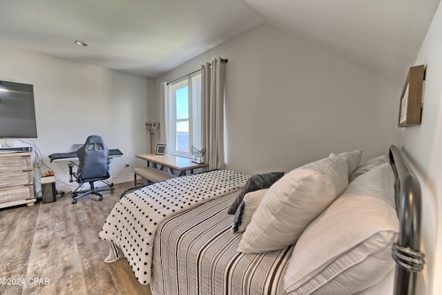 bedroom featuring hardwood / wood-style floors and vaulted ceiling