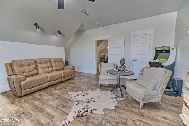 living room with hardwood / wood-style floors, ceiling fan, and vaulted ceiling