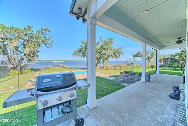 view of patio featuring a water view, area for grilling, and ceiling fan