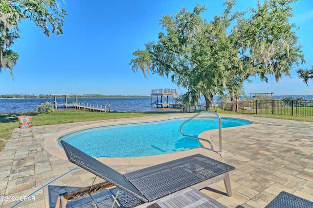 view of pool with a patio area and a water view