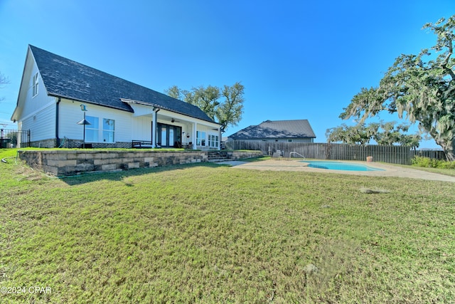 view of yard with a fenced in pool, a patio area, and french doors