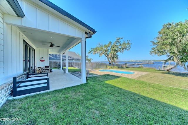 view of yard with ceiling fan, a water view, and a patio