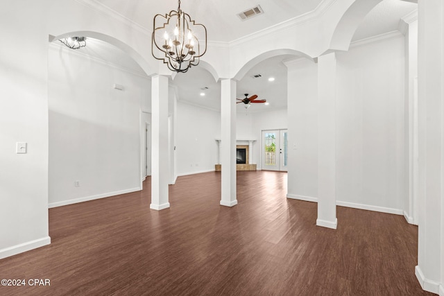 unfurnished living room featuring ceiling fan with notable chandelier, crown molding, dark hardwood / wood-style floors, ornate columns, and a fireplace