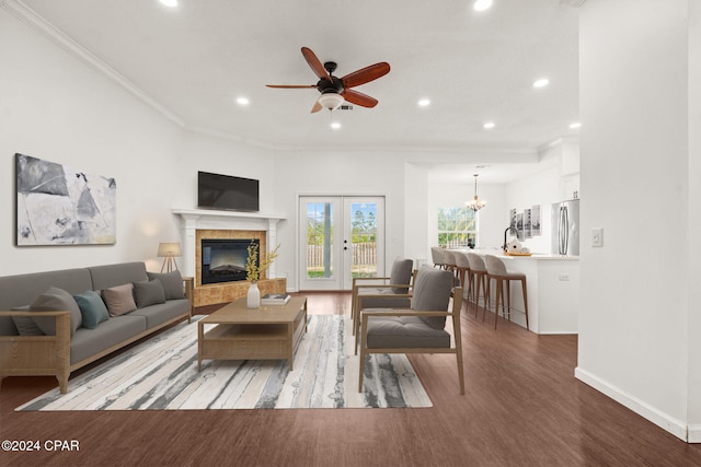 living room featuring french doors, ceiling fan with notable chandelier, sink, hardwood / wood-style flooring, and ornamental molding