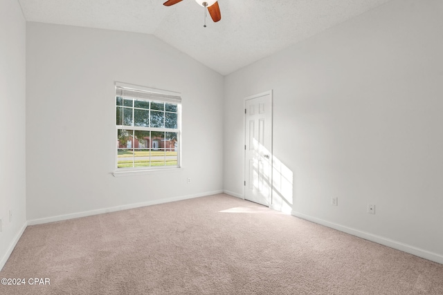 empty room featuring carpet flooring, ceiling fan, and vaulted ceiling