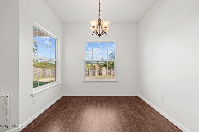 2405 Camryns Xing, Panama City, FL 32405 - unfurnished room with dark wood-style flooring, baseboards, and an inviting chandelier