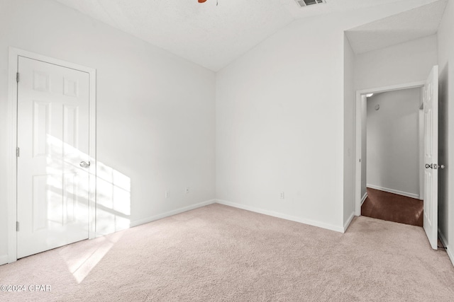 unfurnished bedroom featuring light colored carpet and vaulted ceiling