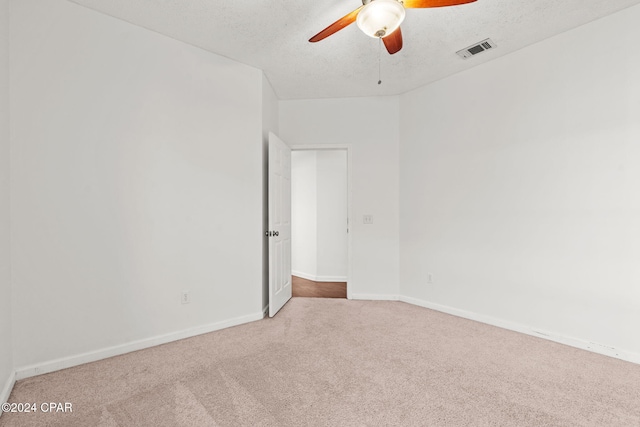 spare room featuring ceiling fan, carpet floors, and a textured ceiling