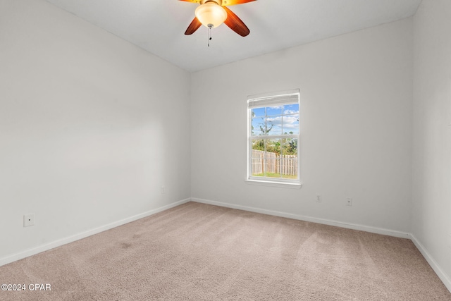 carpeted spare room with ceiling fan