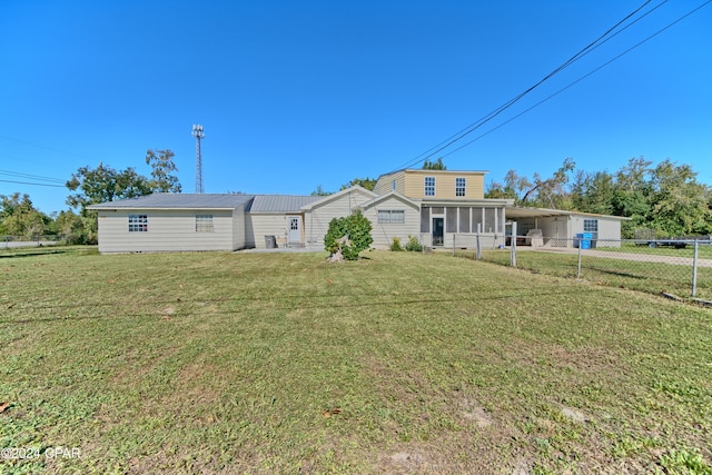 back of property featuring a carport and a lawn