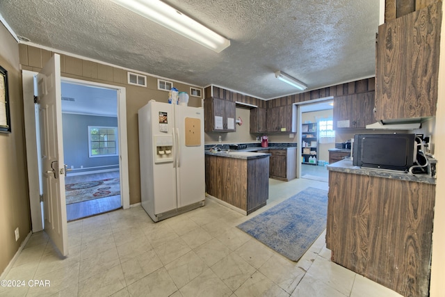 kitchen with white refrigerator with ice dispenser, a textured ceiling, dark brown cabinetry, and plenty of natural light