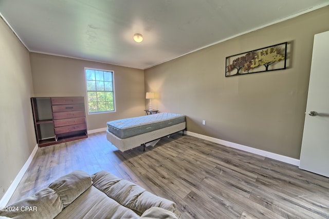 bedroom with crown molding and wood-type flooring