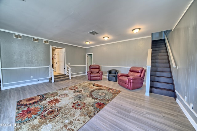 sitting room with ornamental molding and light wood-type flooring