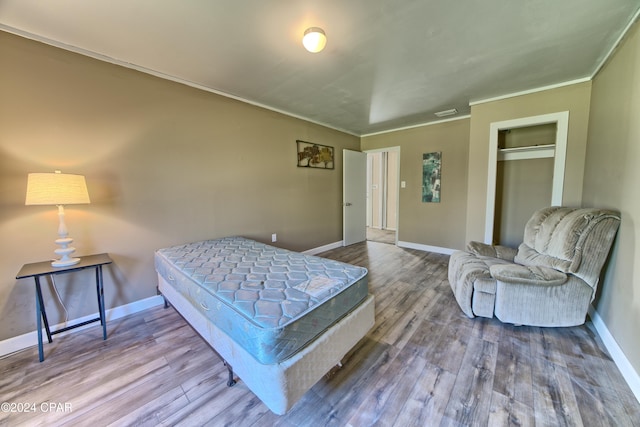 bedroom featuring hardwood / wood-style floors, a closet, and ornamental molding