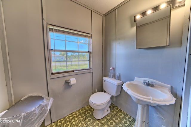 bathroom with sink, a textured ceiling, and toilet