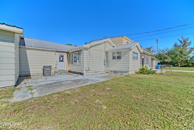 back of property featuring a patio area and a lawn