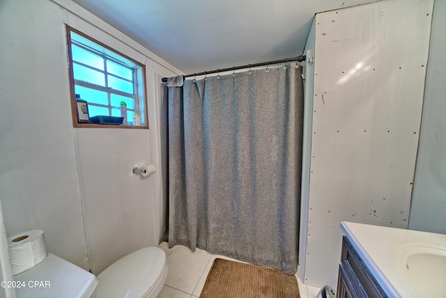 bathroom with toilet, tile patterned flooring, vanity, and walk in shower