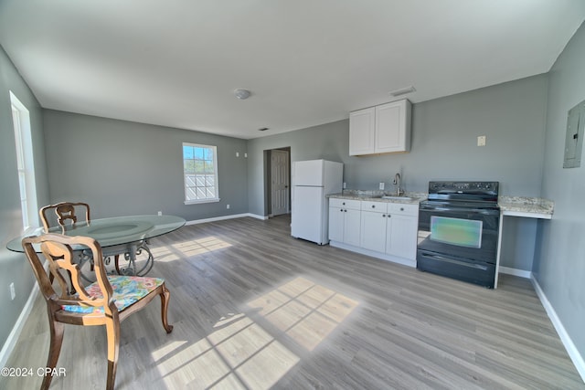 kitchen featuring light wood-type flooring, white cabinets, sink, white refrigerator, and black electric range