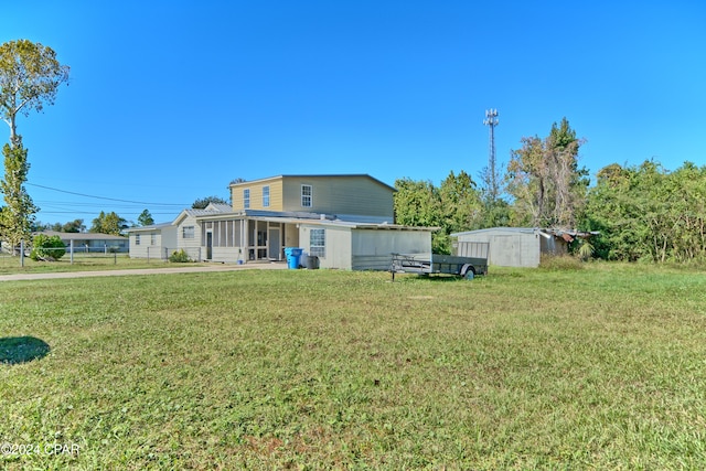 back of property with a storage shed and a lawn