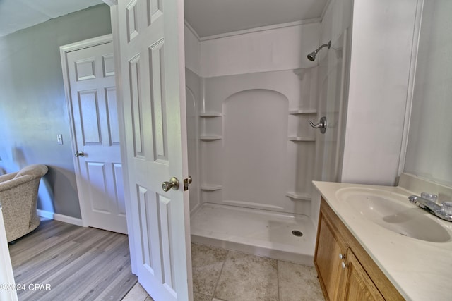 bathroom featuring hardwood / wood-style floors, vanity, and walk in shower