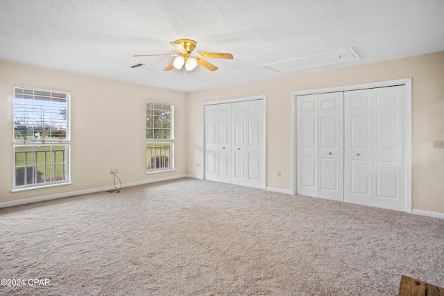 unfurnished bedroom with carpet flooring, ceiling fan, and multiple windows