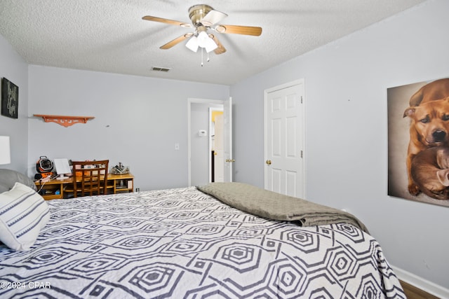 bedroom with ceiling fan and a textured ceiling