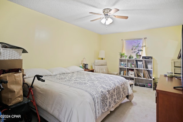 bedroom with a textured ceiling, ceiling fan, and light carpet