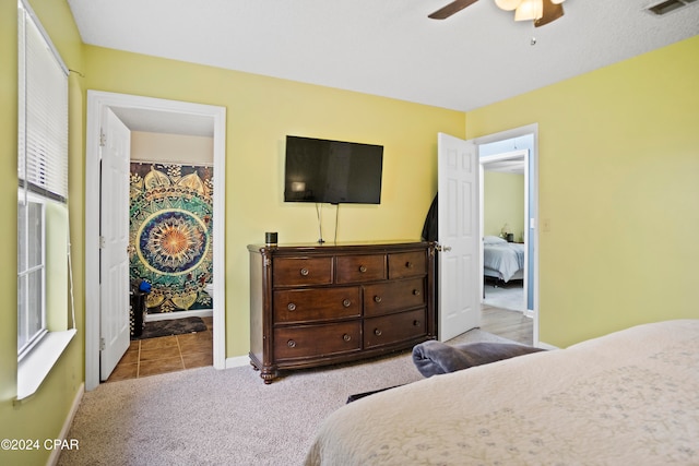 carpeted bedroom with connected bathroom and ceiling fan